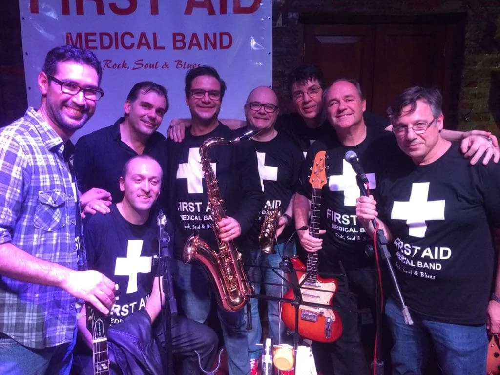 Integrantes da First Aid Medical Band com o banner da banda, no Sgt Peppers, em agosto de 2016